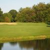 A view over the water of a green protected by bunker at Pleasant Valley Country Club