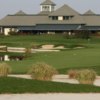 View of a green and clubhouse at Four Bridges Country Club